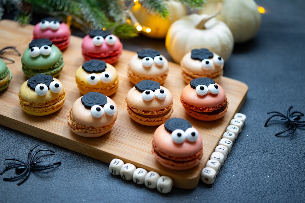 a wooden tray topped with macaroons covered in frosting