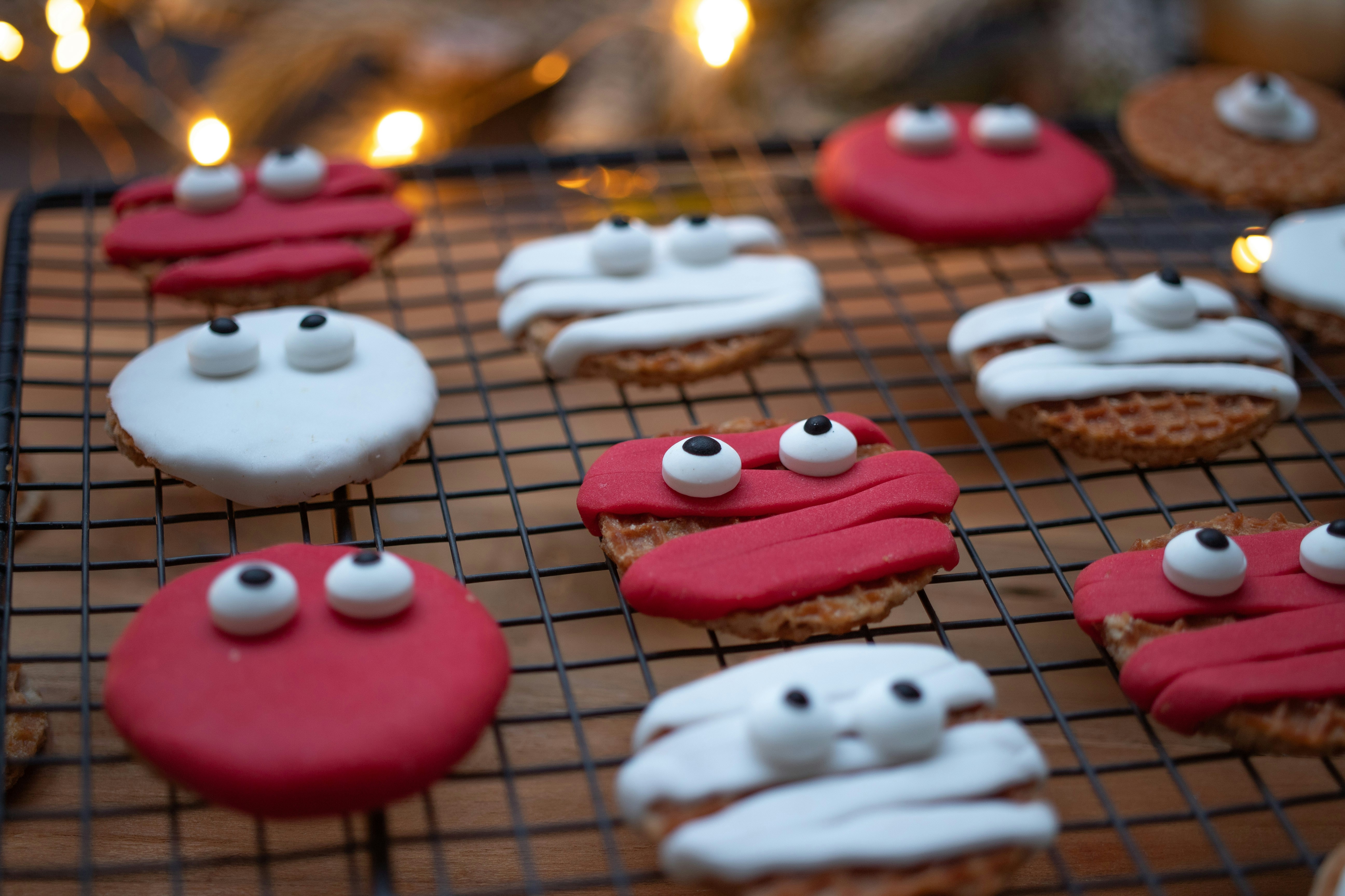 biscotti decorati su una griglia di raffreddamento con candele sullo sfondo