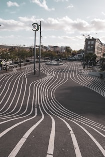 a curved road with a clock tower in the background