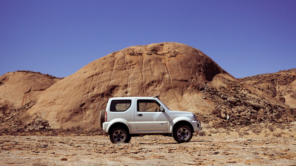 a white pick up truck parked in front of a mountain