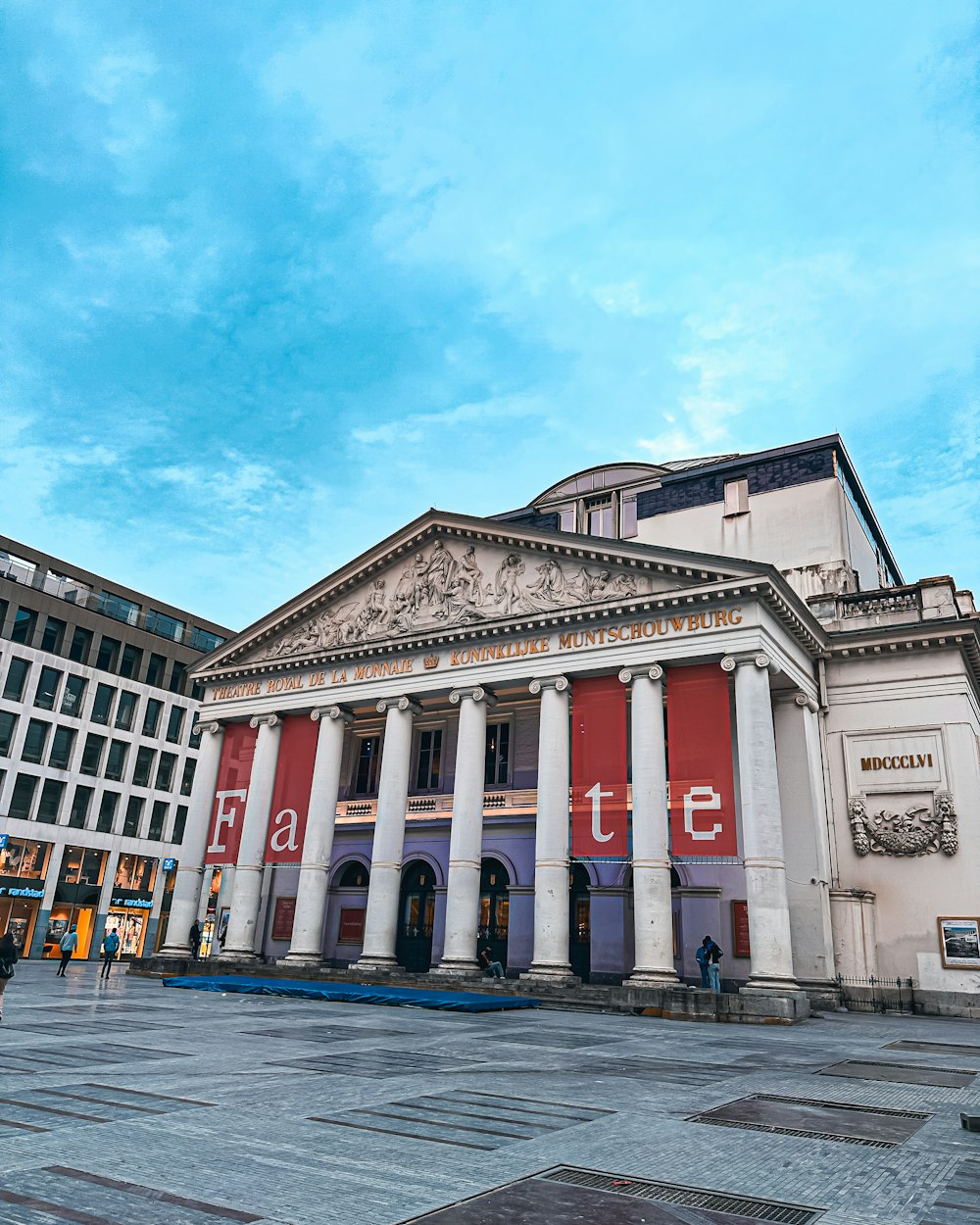 a large building with columns and a sky background