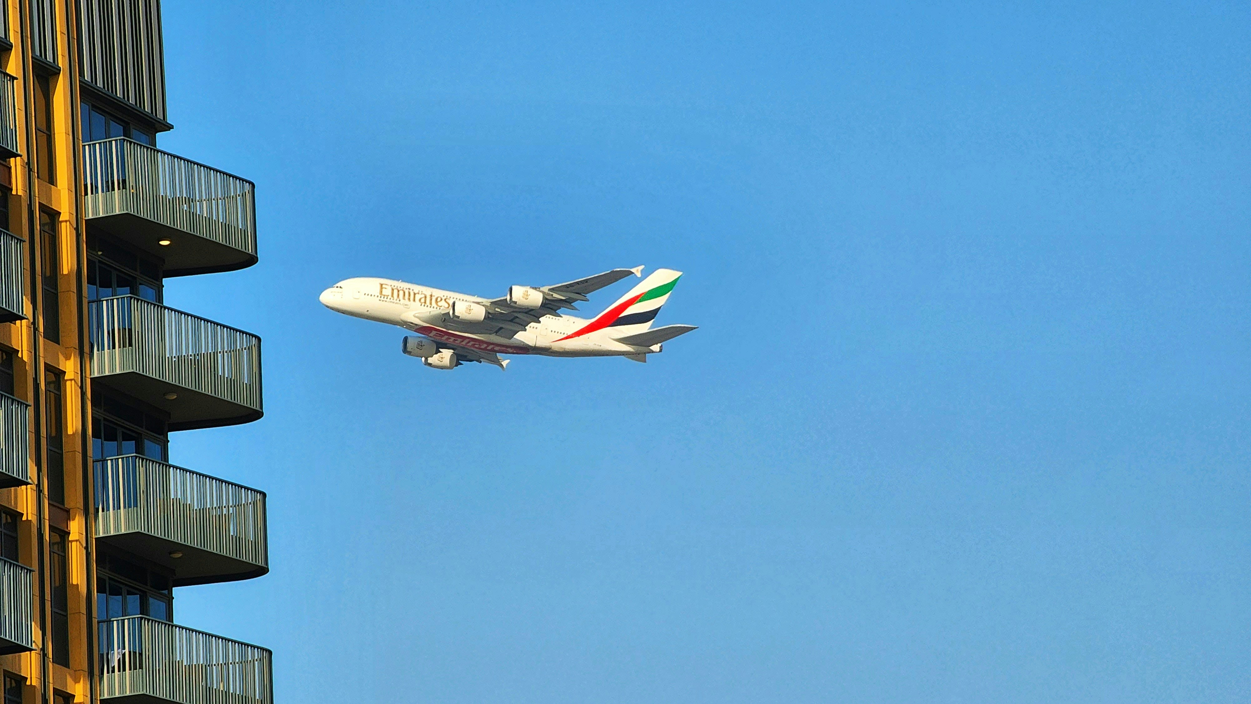 a large jetliner flying through a blue sky, Emirates A380 Flying by..