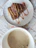 Close-up of a freshly baked brownie with a cup of coffee on a rustic wooden table.