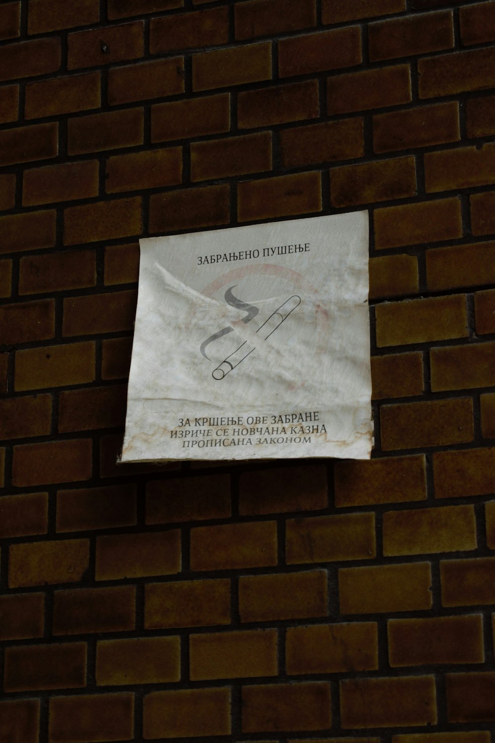 a piece of paper taped to a brick wall