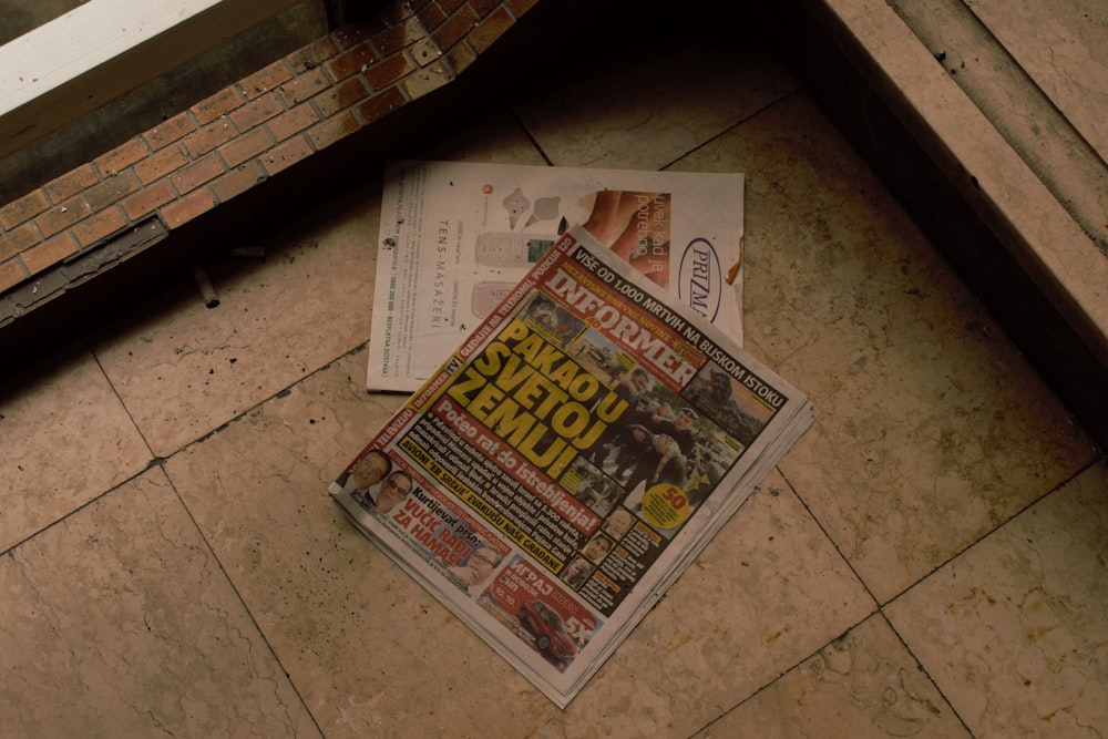 a newspaper laying on the ground next to a window