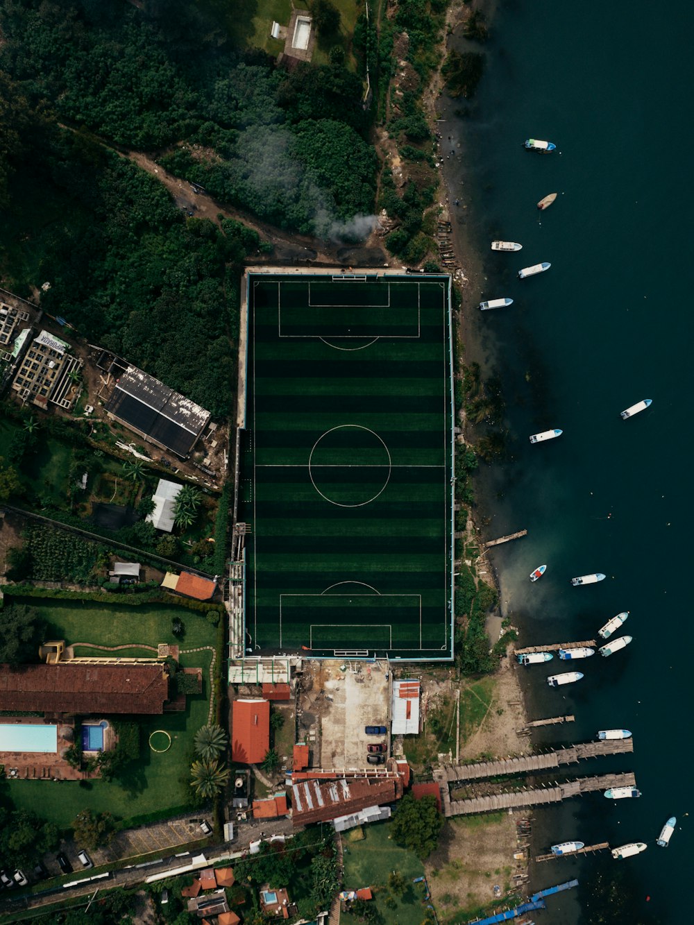 an aerial view of a soccer field next to a body of water