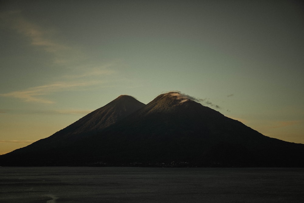 a large mountain rising above a body of water