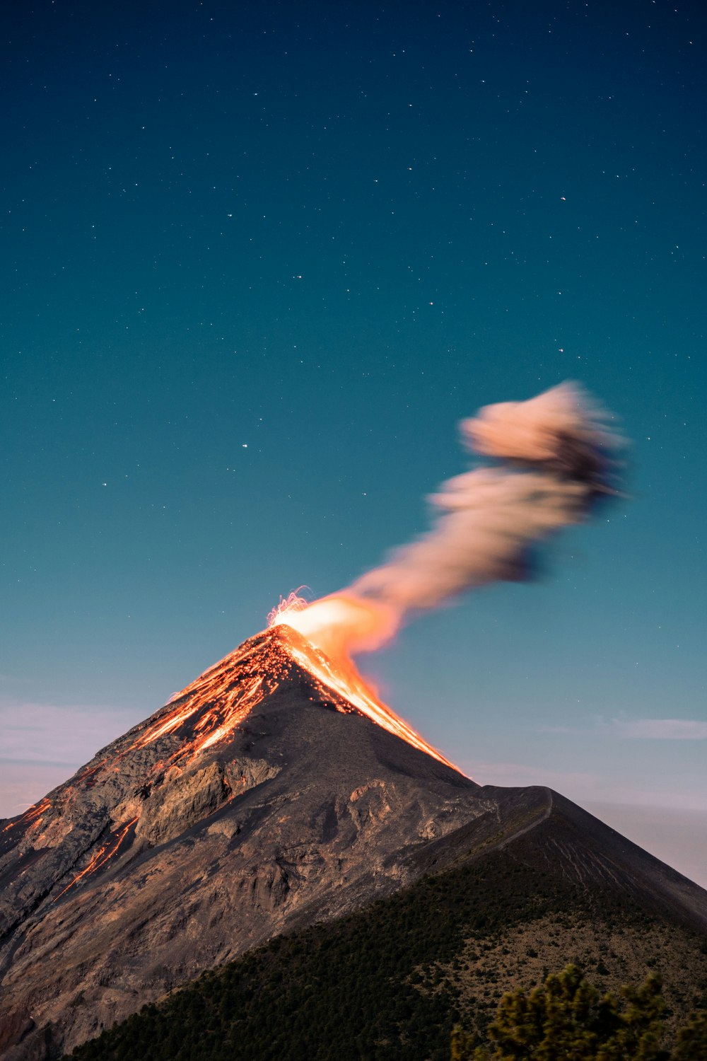 uma montanha com uma grande nuvem de fumaça saindo dela