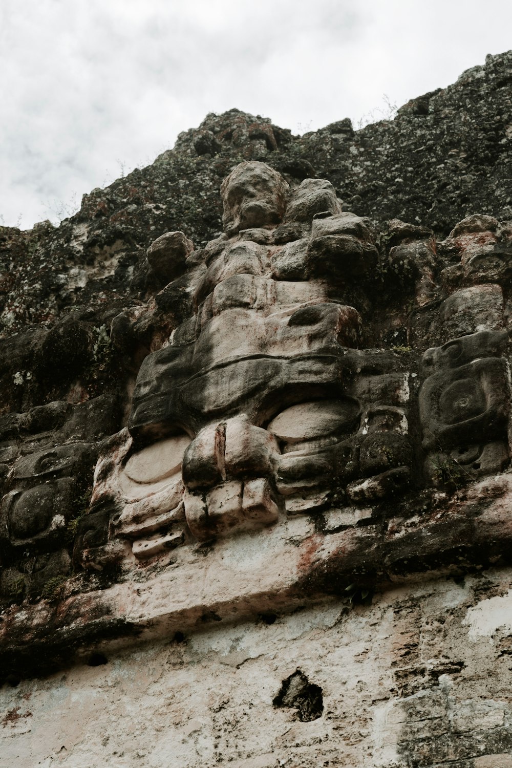 a face carved into the side of a stone wall