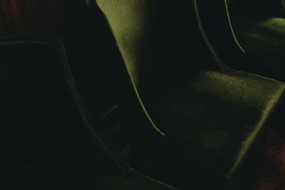 a couple of green chairs sitting on top of a wooden floor
