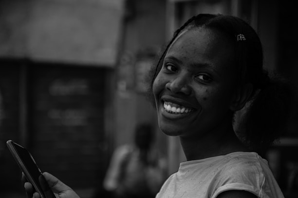 A joyful person reading heartfelt messages on a smartphone with a blurred outdoor background.