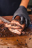 Chef slicing a premium steak with precision in a modern kitchen with red and black accents.