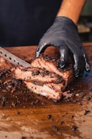 a person cutting a piece of meat with a knife