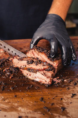 Chef slicing a premium steak with precision in a modern kitchen with red and black accents.