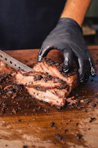 a person cutting a piece of meat with a knife
