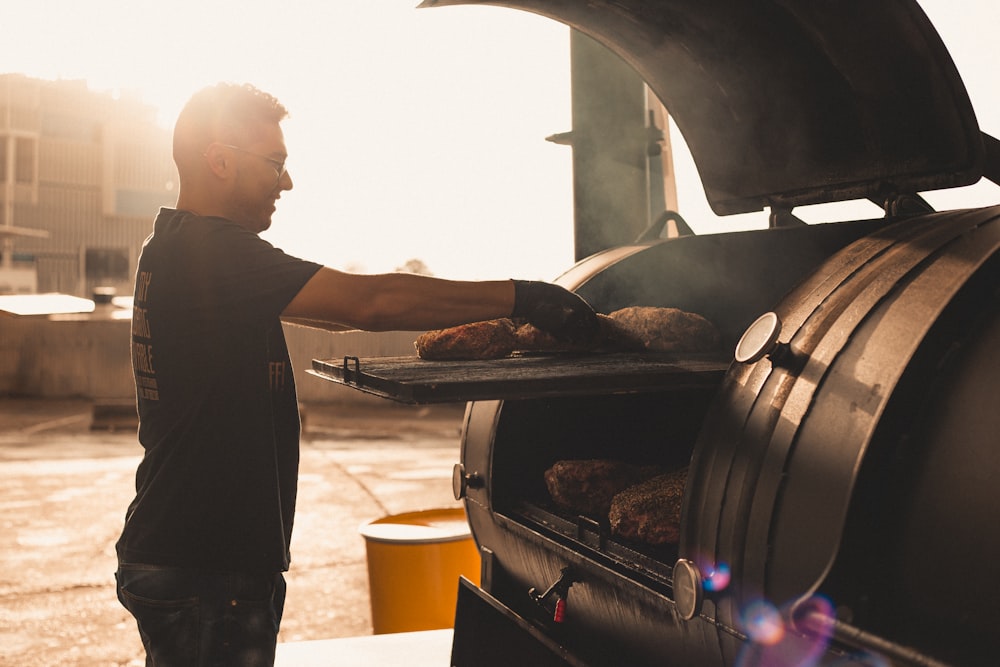 a man cooking food on a grill outside