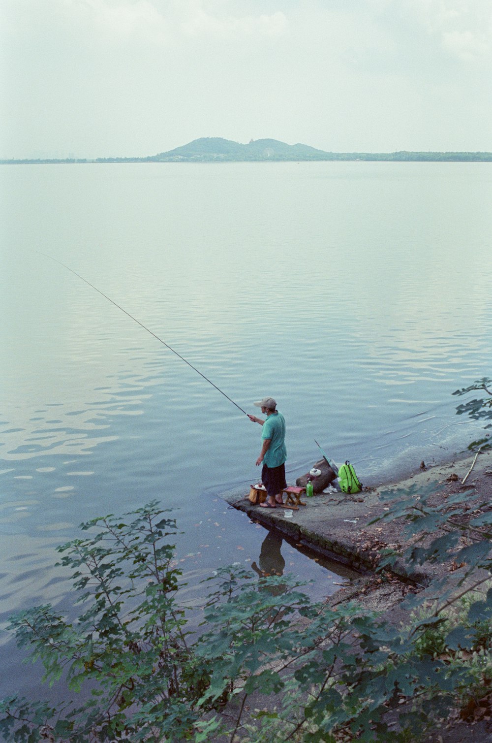 a man standing on a dock with a fishing rod