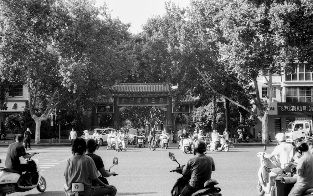 a group of people riding scooters down a street