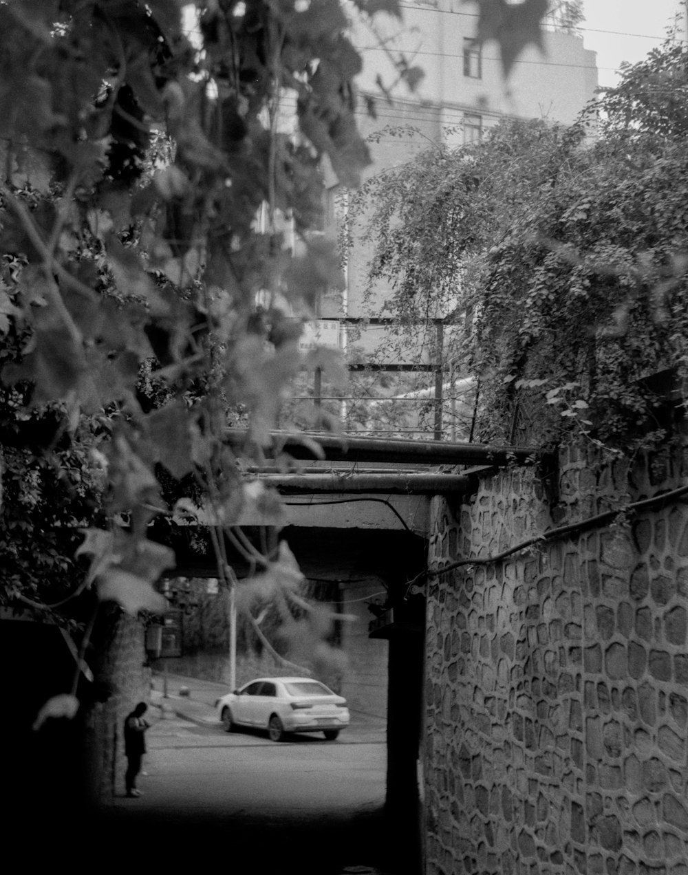 a car driving down a street under a bridge