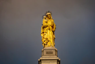 A detailed 3D statuette of San Victorio holding a vintage football, bathed in warm golden light.