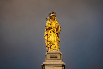 A detailed 3D statuette of San Victorio holding a vintage football, bathed in warm golden light.