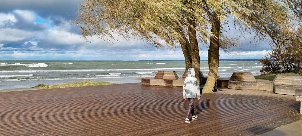 a person standing on a wooden deck next to a tree