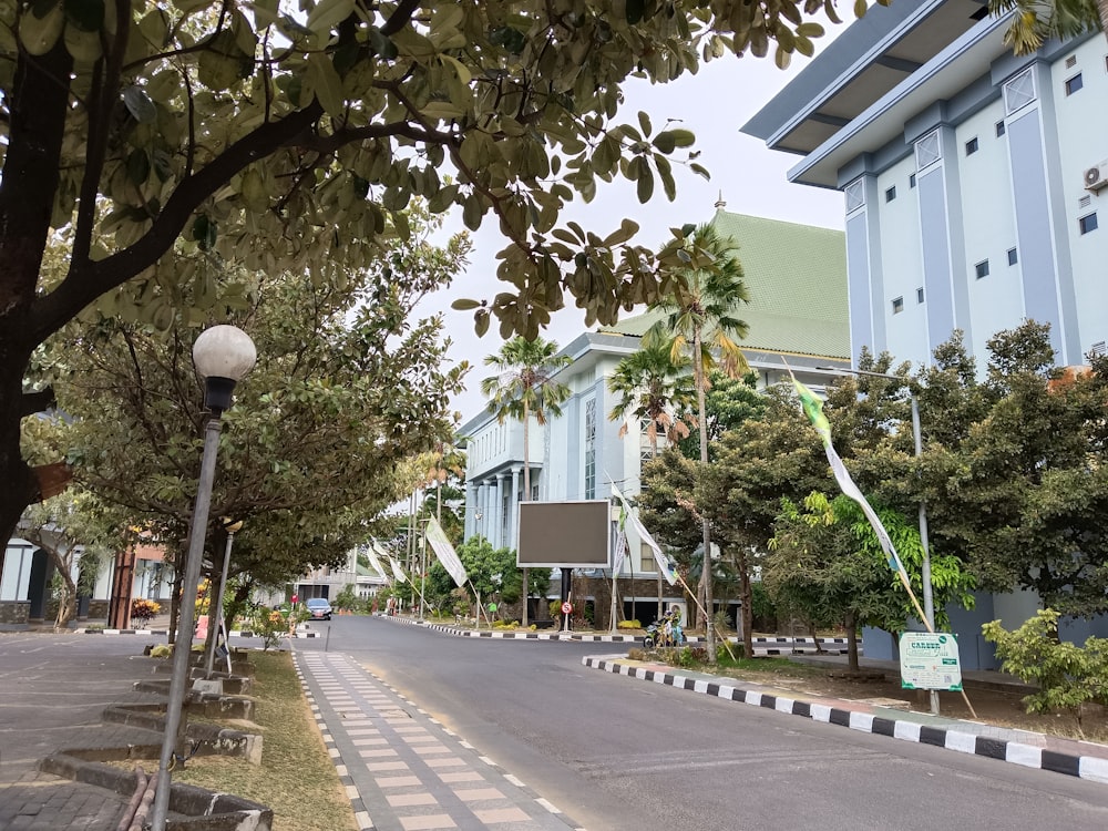 a street lined with trees and buildings next to a street light