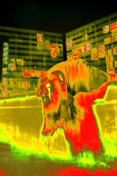 Thermal imaging camera screen showing heat loss patterns on a building facade.