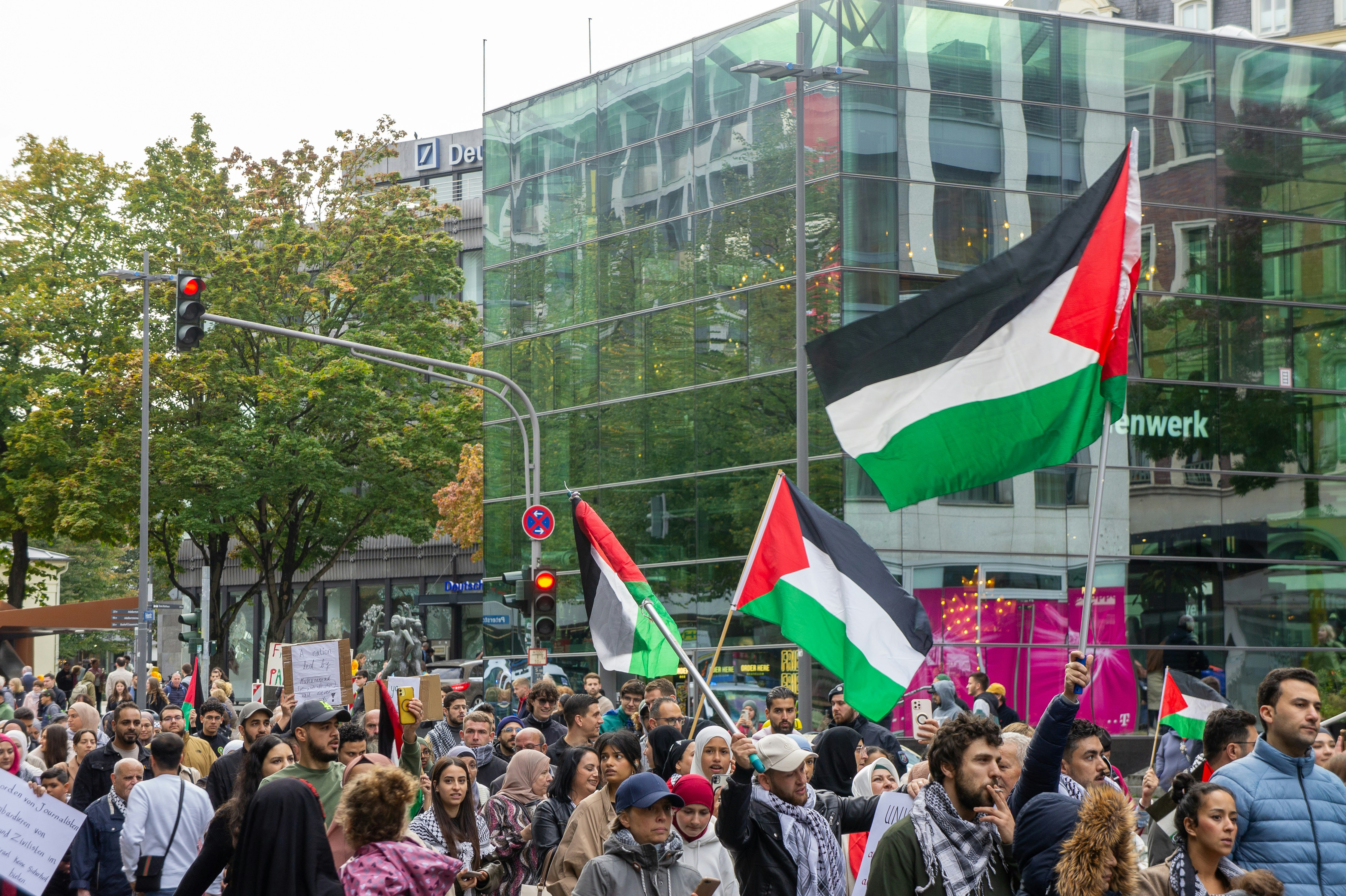 a large group of people holding flags and signs