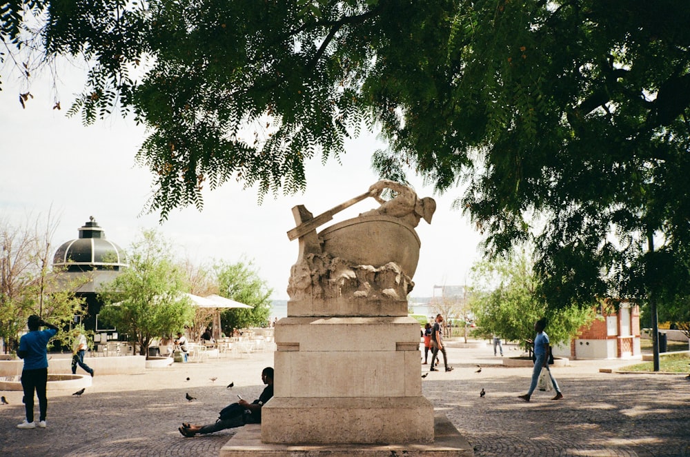 a man laying on the ground next to a statue
