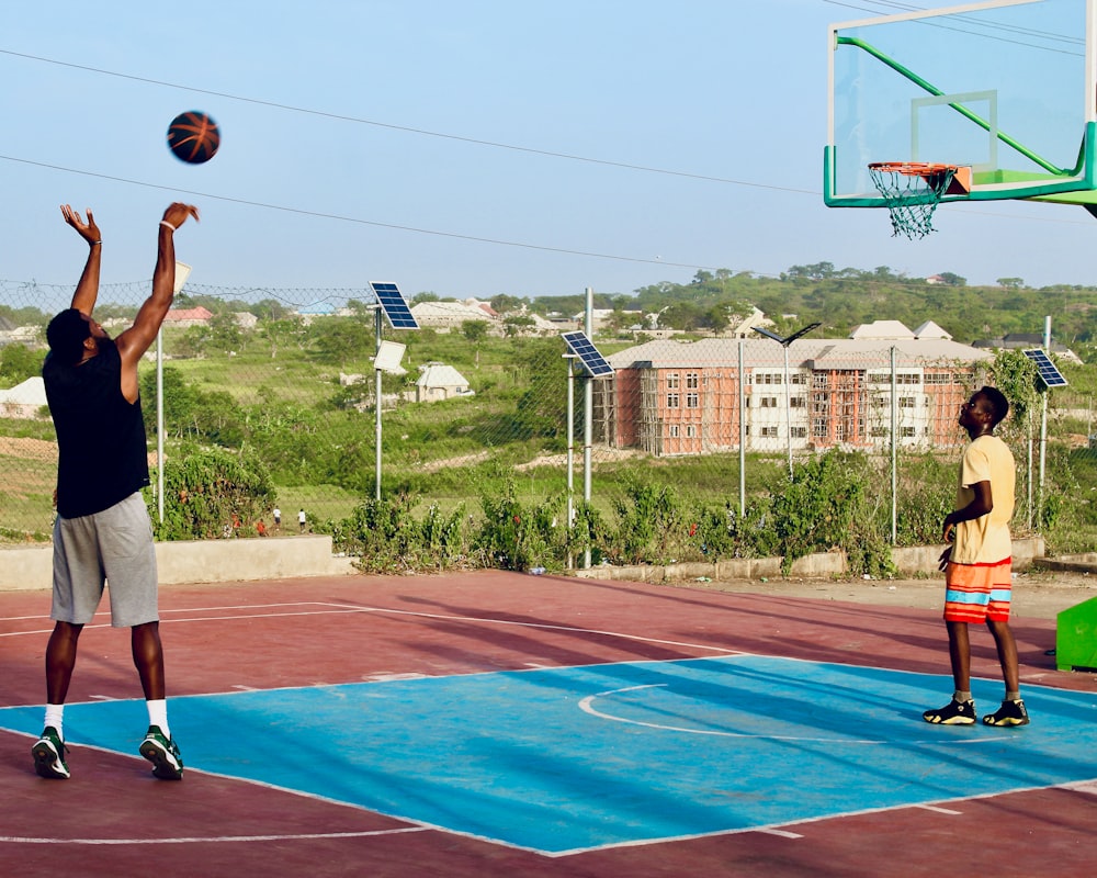 two men playing basketball on a basketball court