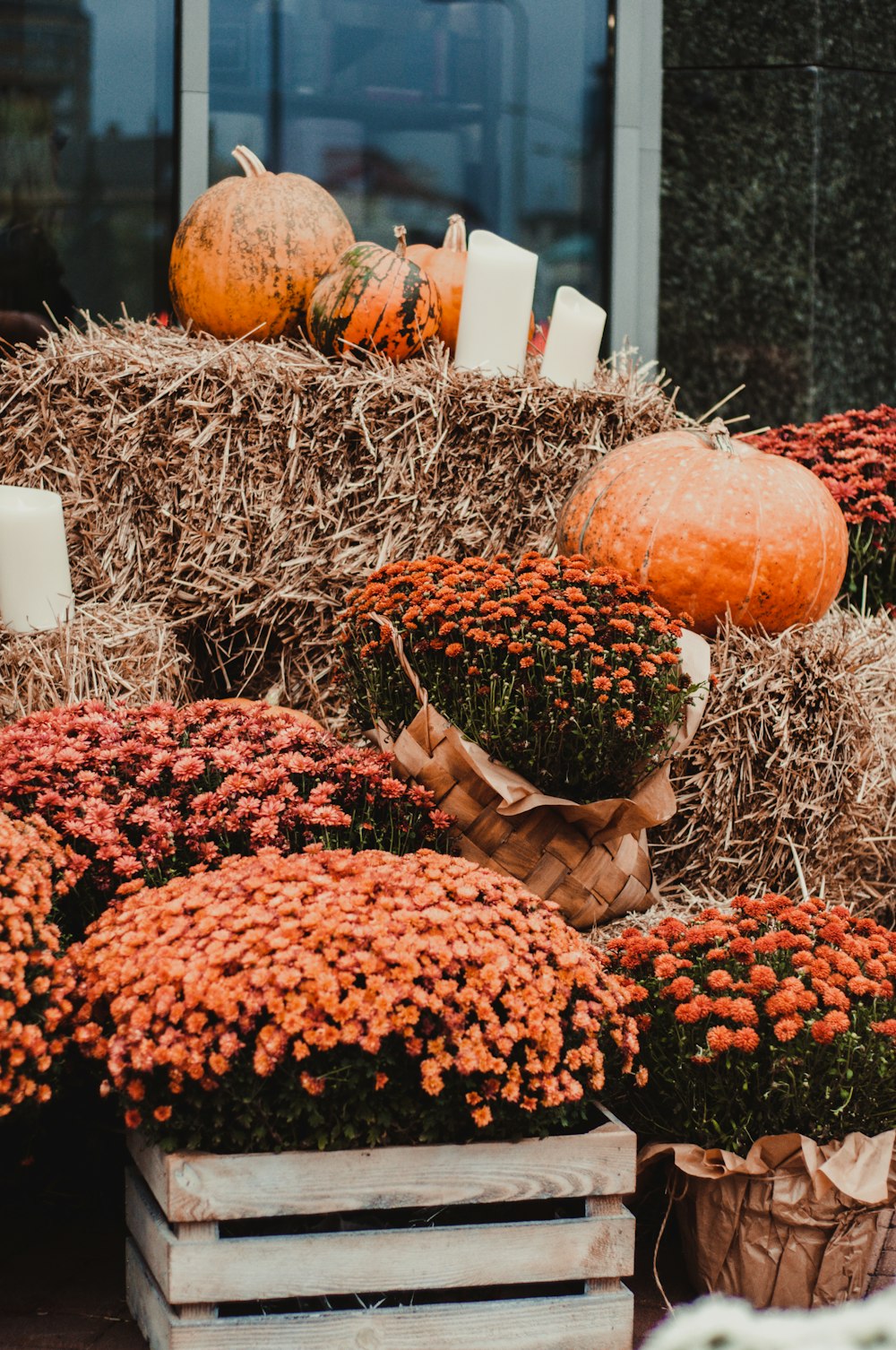 a pile of hay with orange flowers and pumpkins