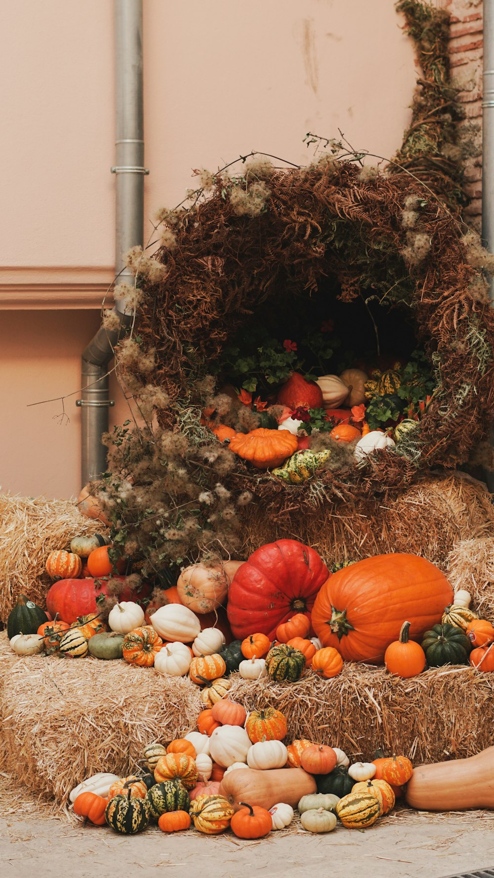 a pile of hay filled with pumpkins and gourds