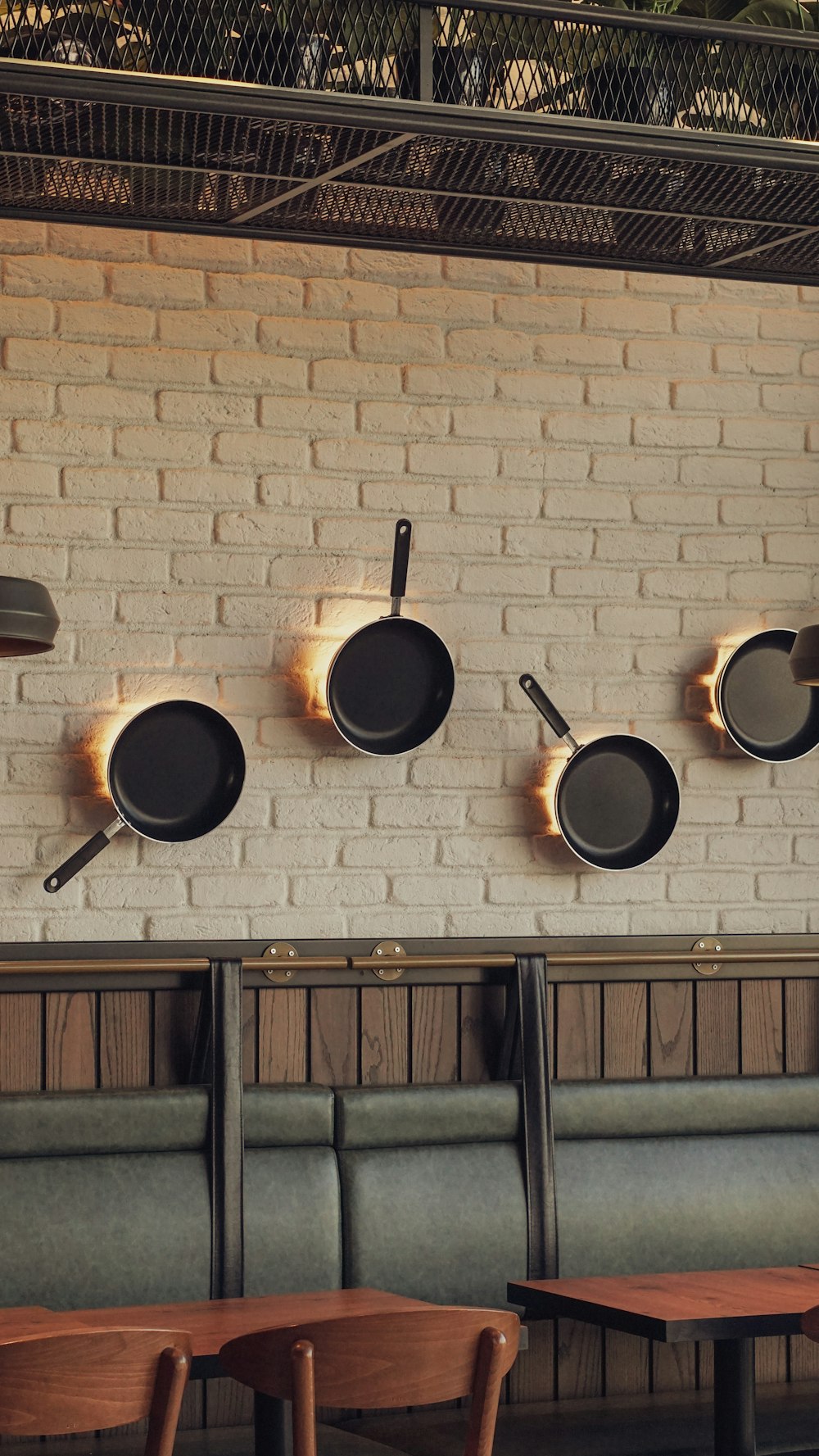 a brick wall with pots and pans hanging on it