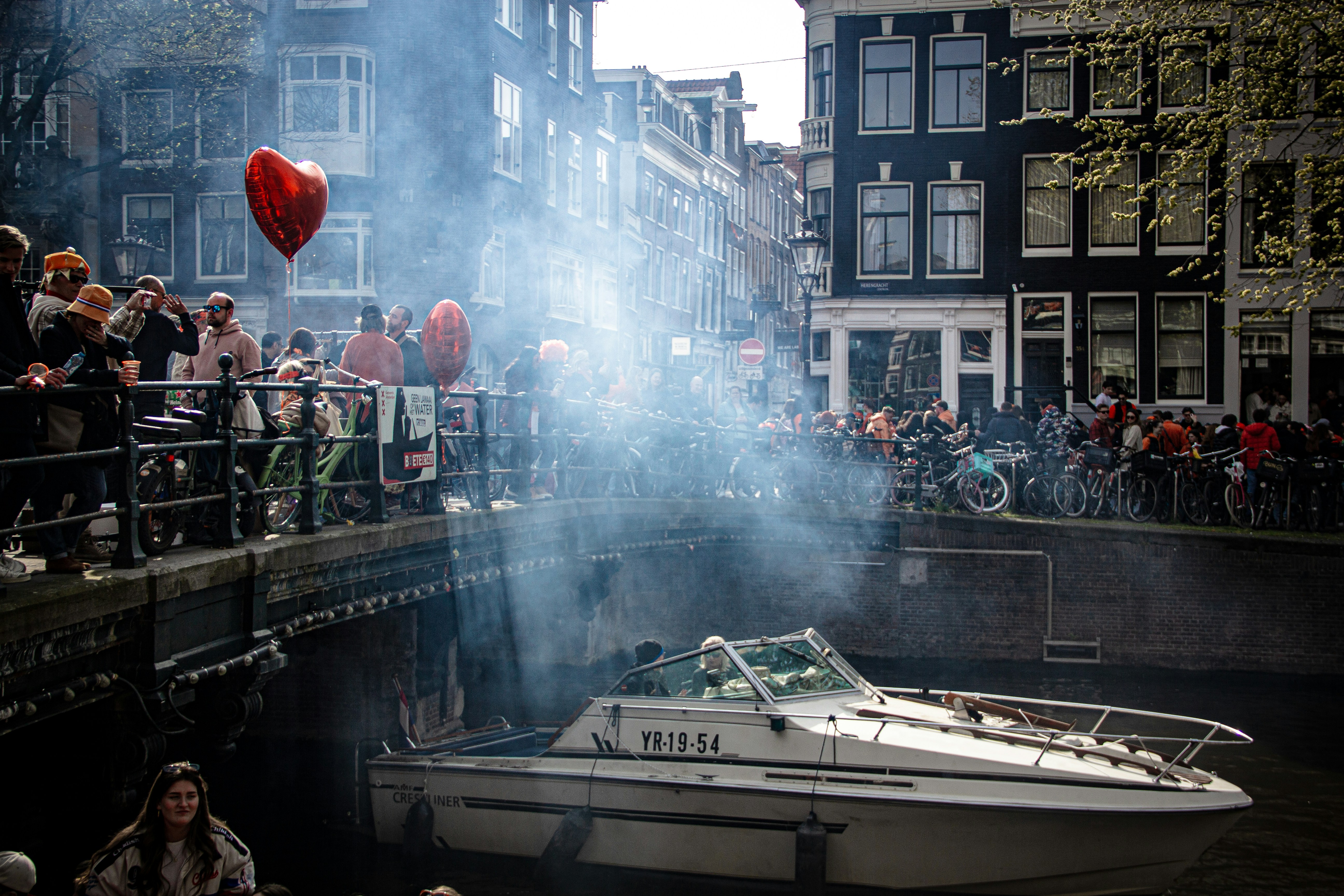 a white boat floating on top of a river next to a crowd of people