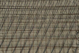 A powerful shot of a steel rebar cage ready for concrete pouring, framed by sharp shadows and gold accents.