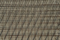 Artistic shot of steel rods casting shadows on a smooth concrete floor.