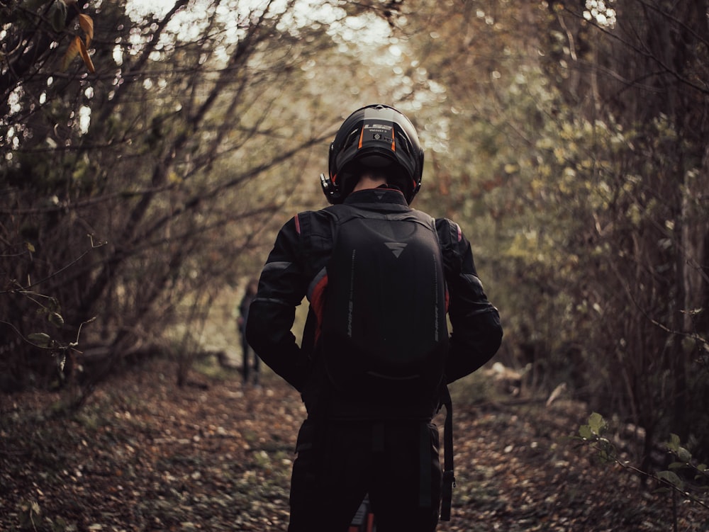 a person with a back pack walking through a forest