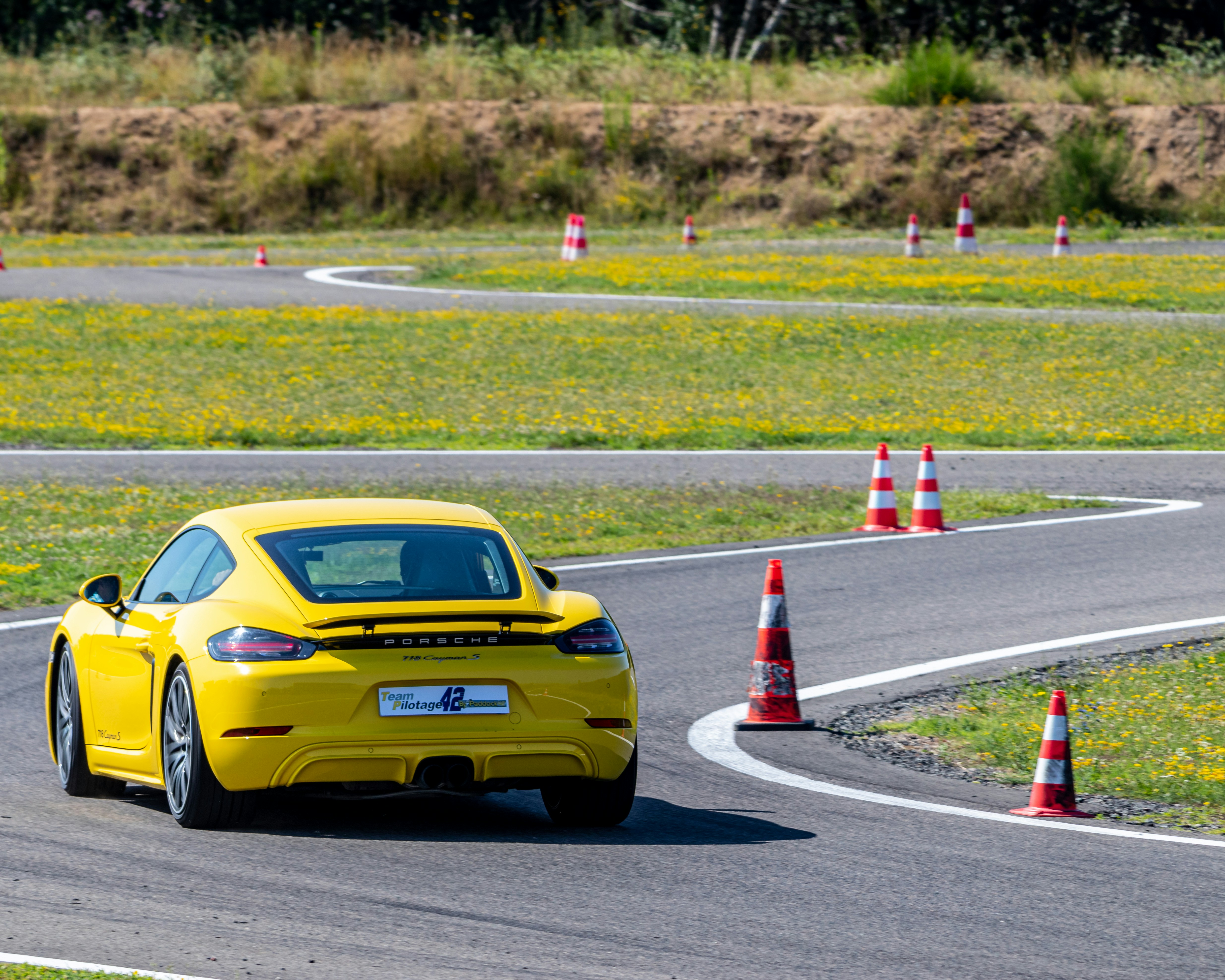 A yellow sports car driving on a race track photo – Free Porsche Image ...