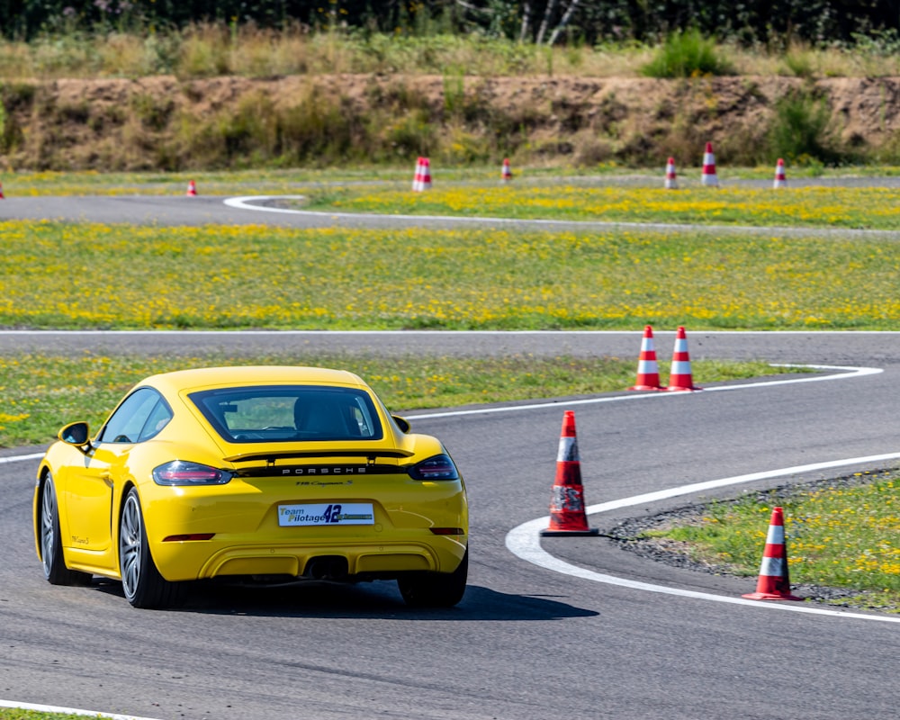 a yellow sports car driving on a race track