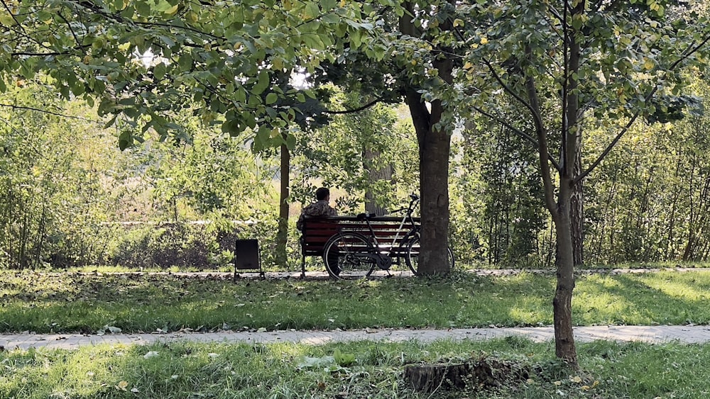 a person sitting on a bench in a park