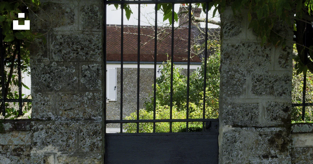 An open gate with a black gate in the middle of it photo – Free ...