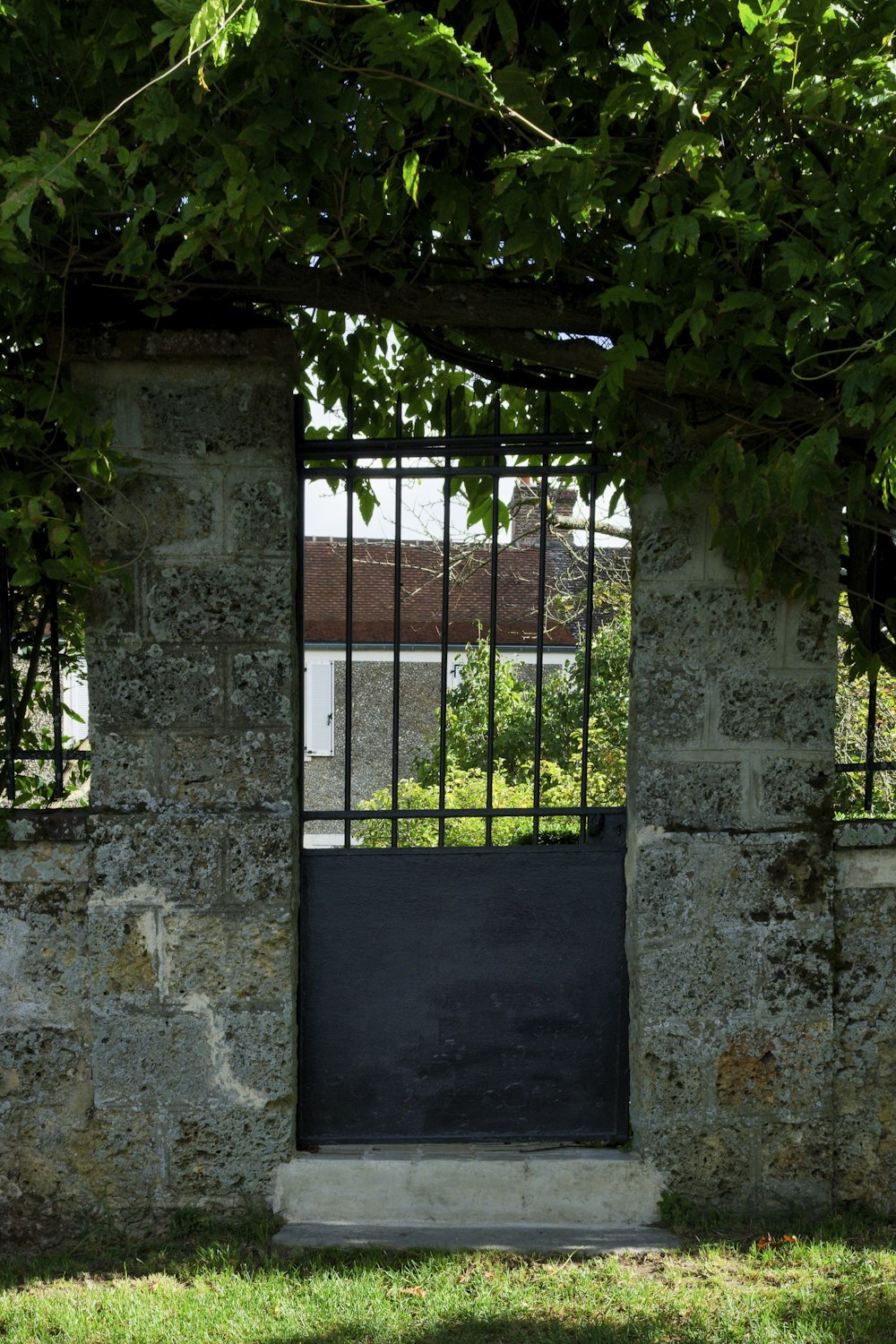 an open gate with a black gate in the middle of it