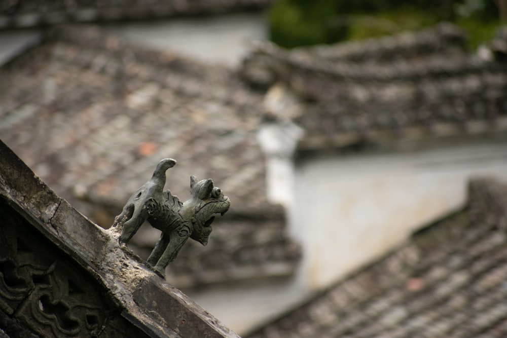 a cat figurine on the roof of a building