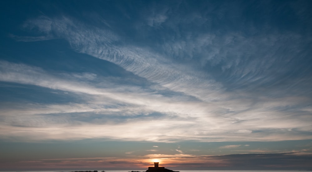 a lighthouse sitting on top of a beach next to the ocean