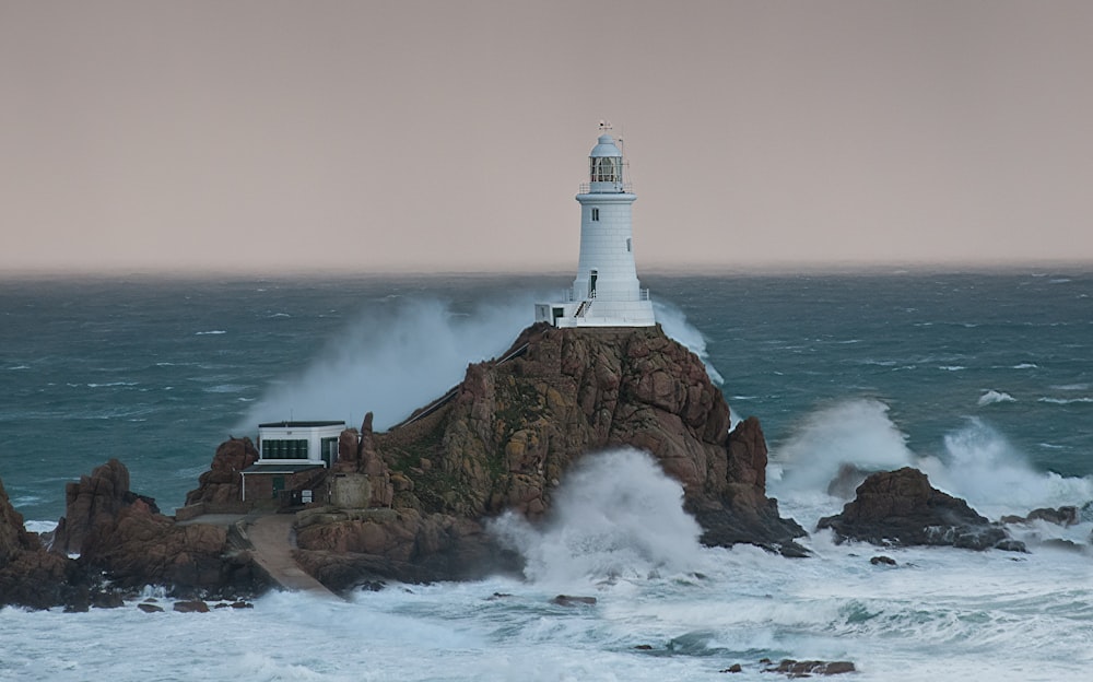 a lighthouse on top of a rock in the ocean