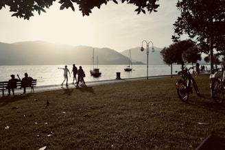 Seniors smiling warmly as they enjoy a serene lakeside sunset on a guided tour.