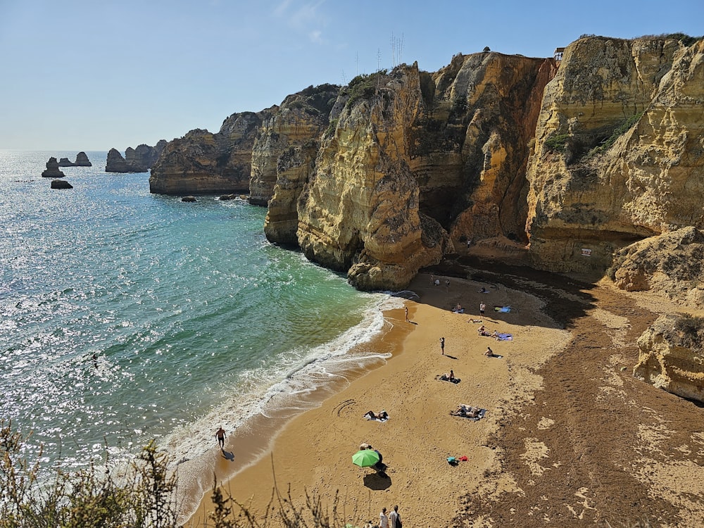 a sandy beach with people on it next to the ocean