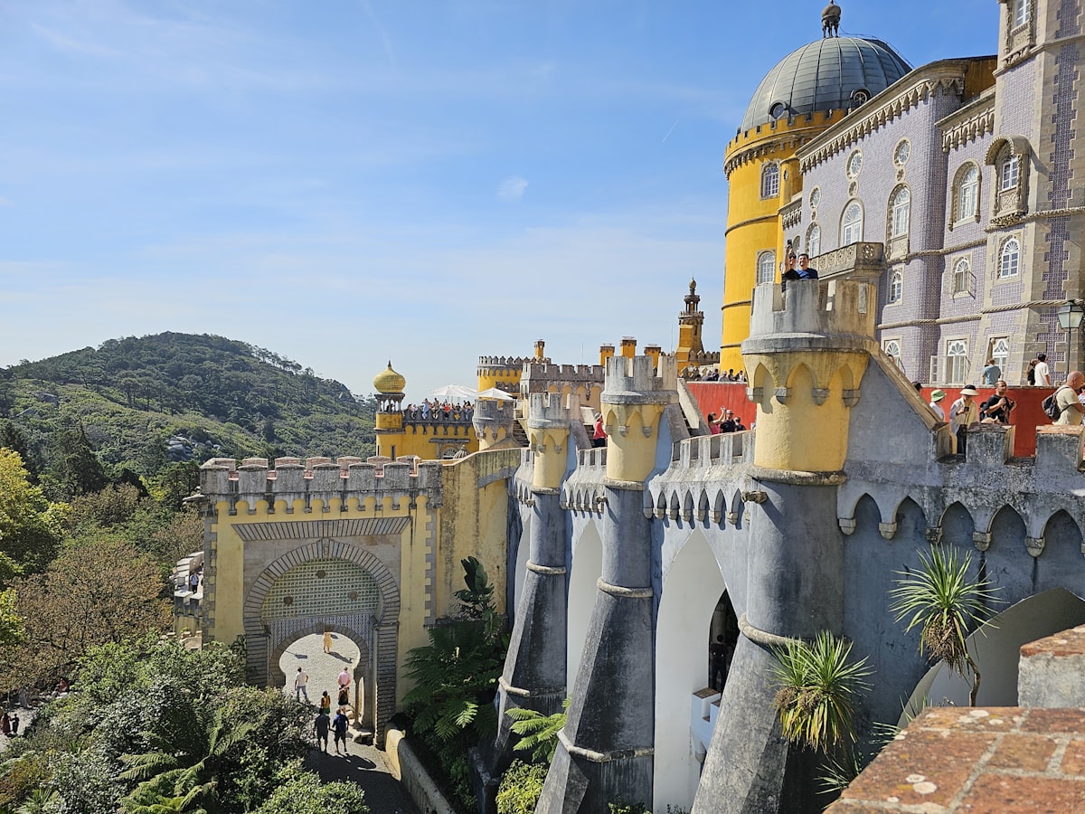 The colorful Pena Palace in Sintra with its yellow and red towers against blue sky
