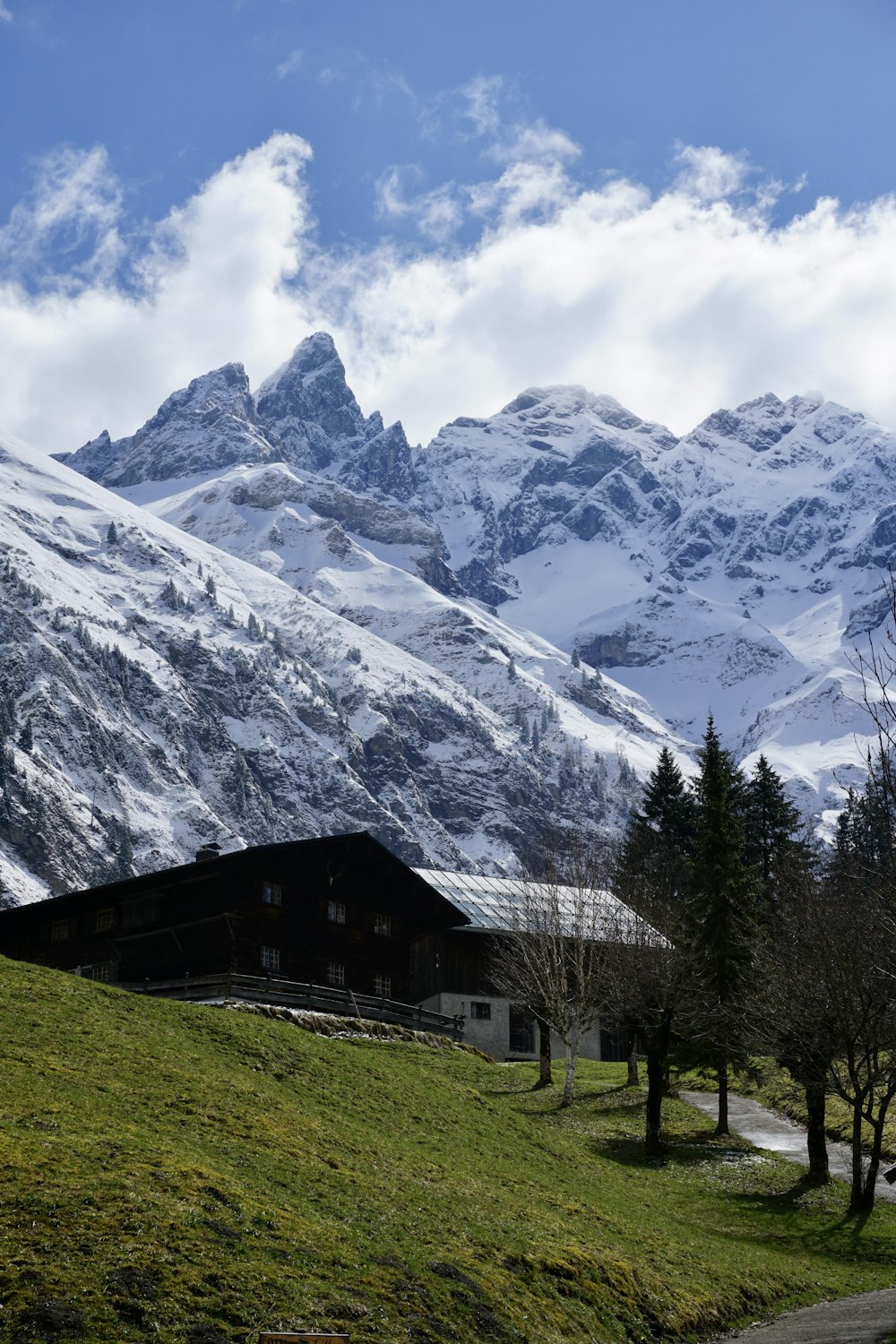 a mountain covered in snow with a barn in the foreground